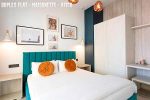 阿利坎特UNIQ flats的卧室配有带橙色枕头的大型白色床