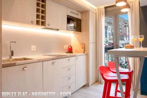 阿利坎特UNIQ flats的厨房配有水槽和一张红色凳子的桌子