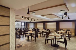 波尔沃林Hotel Orion Centrally near North Goa & Panjim的一间在房间内配有桌椅的餐厅