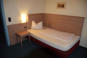 Hotel St. Paulushof的一间小卧室,配有床和床头柜