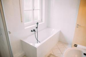 埃尔丁Luxury Suite - Therme ED - Messe MUC - Parken - WLAN的带窗户的浴室内的白色浴缸