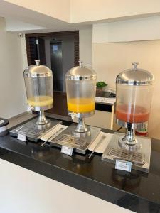 贝洛奥里藏特贝洛奥里藏特广场酒店的一个带两个玻璃搅拌器的柜台,里面装有饮料