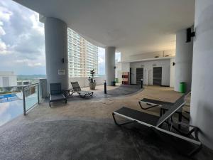 努沙再也Encorp Marina, 2 Bedroom with bathtub, 6 pax, 5mins to LEGOLAND的大型客房,设有椅子和一座游泳池,位于大楼内