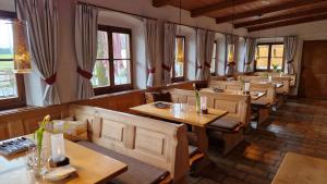 菲施巴豪Hotel Landgasthof Alter Wirt的餐厅设有木桌、椅子和窗户。