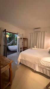 托兰克索Pousada Bem Te Vi Trancoso的卧室配有1张床,享有浴缸的景致