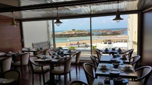 提赫嘎它尔海洋酒店的一间带桌椅的餐厅,享有海滩美景