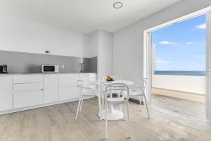 阿鲁卡斯Home2Book Marly Ocean View San Andrés Beach的白色的厨房配有桌椅,享有海景