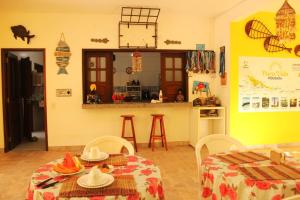 巴雷里尼亚斯Pousada Pura Vida的一间带两张桌子的客厅和一间厨房