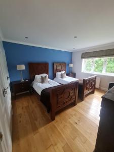 邓巴The Bridge House, Dunbar的一间卧室设有两张床和蓝色的墙壁