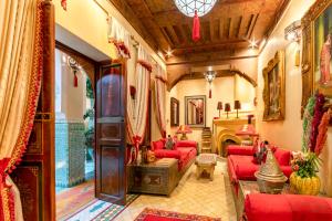 马拉喀什利亚德童话庭院旅馆的客厅设有红色的沙发和壁炉
