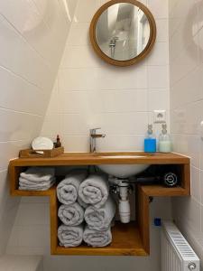 霍恩City-beach apartment nearby Amsterdam的浴室设有水槽和一堆毛巾