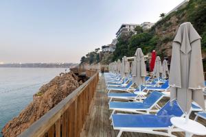 安塔利亚安塔利亚华美达广场酒店的码头上一排带遮阳伞的沙滩椅