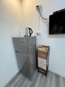 Ban Khae TaphaoNuttida resort ณัฐธิดา รีสอร์ท的墙上有电视的冰箱