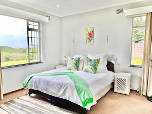 圣卢西亚St Lucia Holiday Cottage的卧室配有带白色墙壁和窗户的床