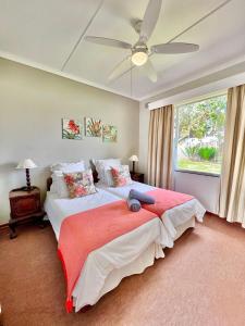 圣卢西亚St Lucia Holiday Cottage的一间卧室配有两张床和吊扇