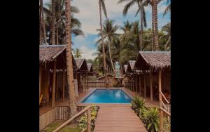锡基霍尔The Bangka Beach Guesthouse的一个带游泳池和棕榈树的度假村