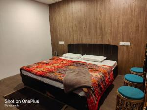 乔斯希马特Auli Eco Nature Resort的一间卧室配有一张床和两张凳子