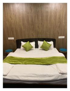 乔斯希马特Auli Eco Nature Resort的一张带绿色和白色枕头的床