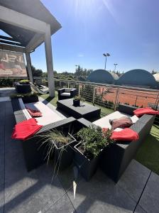 波兹南Hotel Restauracja Tenis Kortowo的屋顶上种有长沙发和盆栽植物的庭院