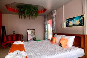 巴色Heaven Guesthouse的一间卧室配有一张带橙色枕头的大床