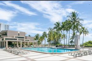 迈阿密KEY BISCAYNE BEACH VACATION #3的一个带游泳池、椅子和棕榈树的度假村