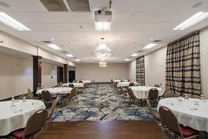 梅肯梅肯温德姆集团温盖特酒店的宴会厅配有桌椅和白色的桌布