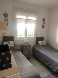 奇克拉纳－德拉弗龙特拉Appart T3 à louer en Andalousie的一间卧室设有两张单人床和一个窗户。