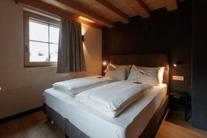 利维尼奥Snow Villa Genf with Spa的卧室配有一张大白色床和窗户