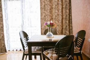 巴统Ekaterine's Apartments的餐桌、椅子和花瓶