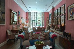 纽约克罗斯比街酒店的客厅设有粉红色的墙壁、沙发和椅子