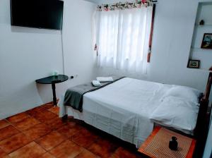卡拉瓜塔图巴Villavera - Caragua Centro的一间卧室配有一张床、一张桌子和一个窗户。
