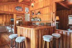 圣马丁德洛斯Hostería Villarino的一间酒吧,位于一个木墙和凳子的房间