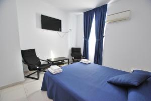 滨海比拉萨尔Hotel Tres Leones的一间卧室配有蓝色的床和两把椅子