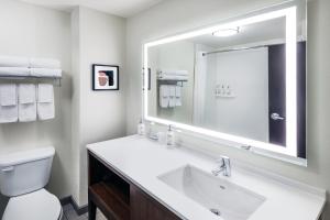 斯蒂尔沃特斯蒂尔沃特大学西假日酒店及套房的白色的浴室设有水槽和镜子