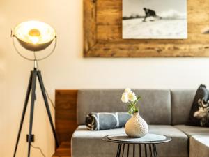 布雷根茨沃尔德地区奥Huus123的客厅配有沙发和带花瓶的桌子