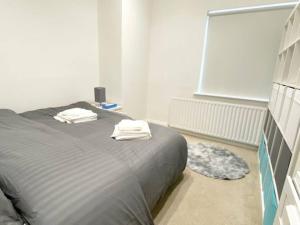 伦敦2 Bedroom Flat in Whitechapel!的一间卧室配有一张床,上面有两条毛巾