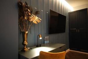 克莱佩达Comfort Hostel Klaipeda的客房设有带花瓶和椅子的书桌。