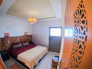 塔姆拉赫特乌兹达尔Atlantic Vibes Surf Hostel的一间卧室设有一张大床和一个窗户。