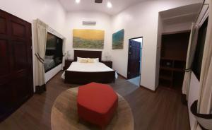 德雷克Drake Bay River View的一间卧室配有一张床和红色凳子