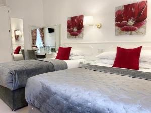 都柏林德格瓦罗酒店的宿舍间内的两张床,配有红色枕头