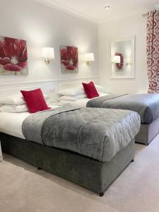 都柏林德格瓦罗酒店的卧室内的两张床,配有红色枕头