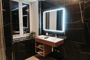 德莱蒙Hôtel du Midi的一间带水槽和镜子的浴室
