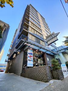 温哥华Divya Sutra Suites on Robson Downtown Vancouver的餐馆前有标志的建筑物