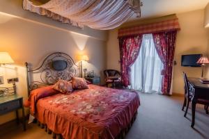 Cintruénigo阿拉马酒店的一间卧室配有一张床、一张书桌和一个窗户。