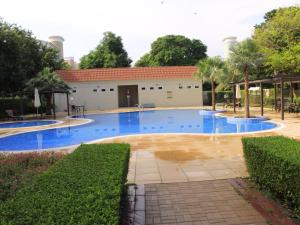 迪拜Dreams Hostel的一座大型游泳池,其建筑背景为: