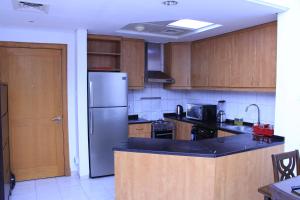 迪拜Dreams Hostel的厨房配有不锈钢冰箱和木制橱柜