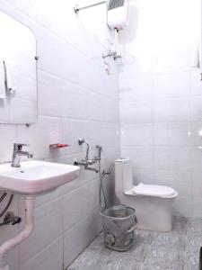 RājgarhBAGH VILLA HOME STAY的白色的浴室设有水槽和卫生间。