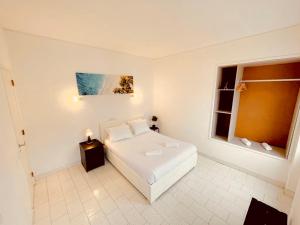 卡帕里卡海岸Central Atlantic Beach Guesthouse的卧室配有白色的床和窗户。