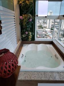 戈亚尼亚Banho de Lua - Vaca Brava的带窗户的浴室内的按摩浴缸
