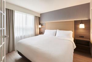 渥太华Holiday Inn & Suites Ottawa Kanata, an IHG Hotel的卧室设有一张白色大床和一扇窗户。